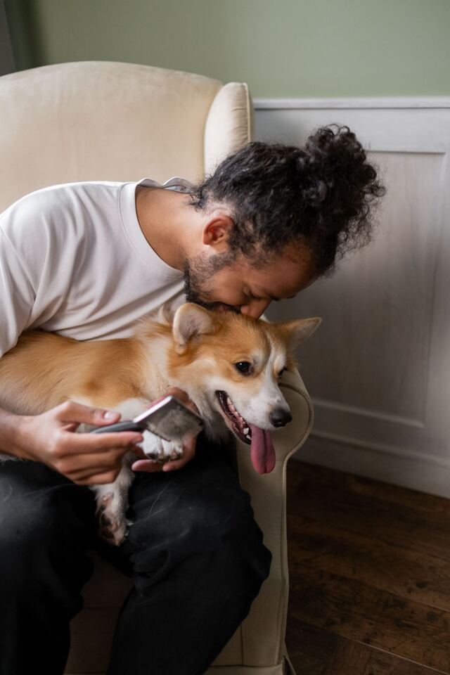 Man hugging his corgi